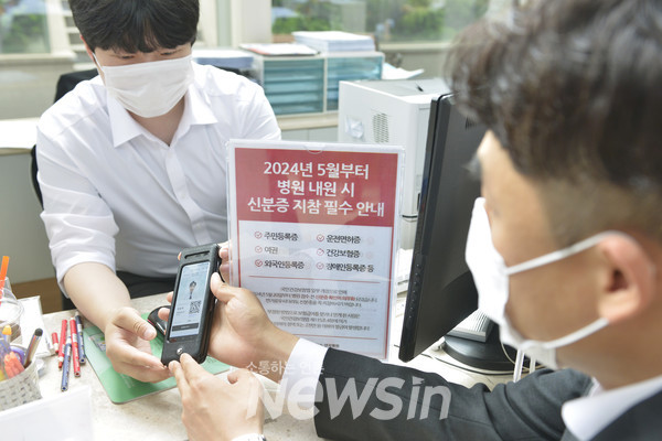 ▲‘요양기관 본인확인 강화 제도’가 시행된 20일 서울 관악구 에이치플러스 양지병원 원무팀 직원이 환자 모바일 신분증을 확인하며  환자 본인 확인 절차를 시행하고 있다. (사진=H+ 양지병원)