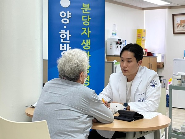 [사진설명] 분당자생한방병원 의료진이 진료소를 찾은 어르신을 문진하고 있다