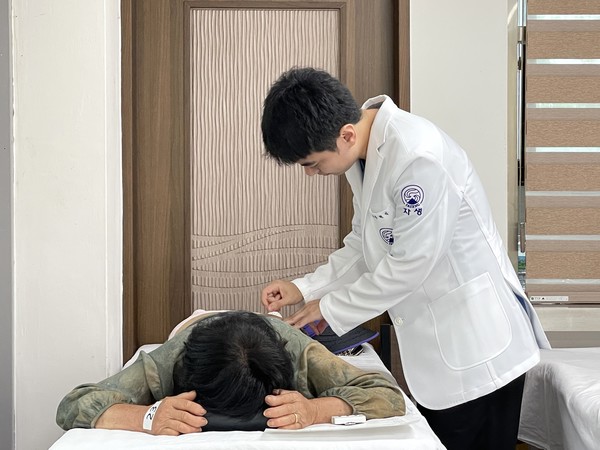 [사진설명] 자생한방병원 의료진이 진료소를 방문한 어르신에게 침치료를 진행하고 있다