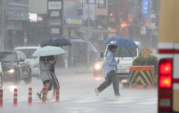 정체전선이 북상하며 호우경보가 내려진 20일 오후 제주 서귀포시 서홍동 인근 횡단보도에서 우산을 쓴 시민들이 걸어가고 있다. 2024.06.20.