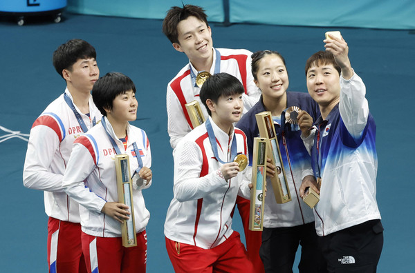 임종훈과 신유빈이 30일(현지시각) 프랑스 파리 사우스 파리 아레나에서 열린 2024 파리 올림픽 탁구 혼합복식 시상식에서 동메달을 목에 걸고 금메달을 획득한 중국의 왕추친-쑨잉사, 은메달을 획득한 북한 리정식-김금용과 함께 기념촬영을 하고 있다. 2024.07.30.