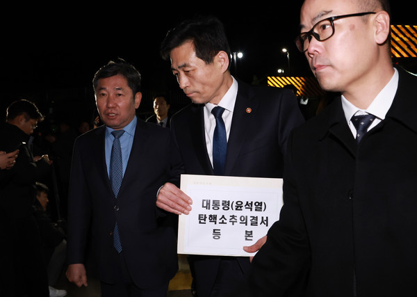 윤석열 대통령의 국회 탄핵소추안이 가결된 14일 김민기 국회 사무총장이 탄핵소추의결서를 송달하기 위해 서울 용산 대통령실 청사 입구에 도착해 내부로 이동하고 있다. 왼쪽은 조오섭 국회의장 비서실장. 탄핵소추의결서가 대통령실에 송달되는 즉시 윤 대통령의 직무가 정지된다. (대통령실통신사진기자단) 2024.12.14.