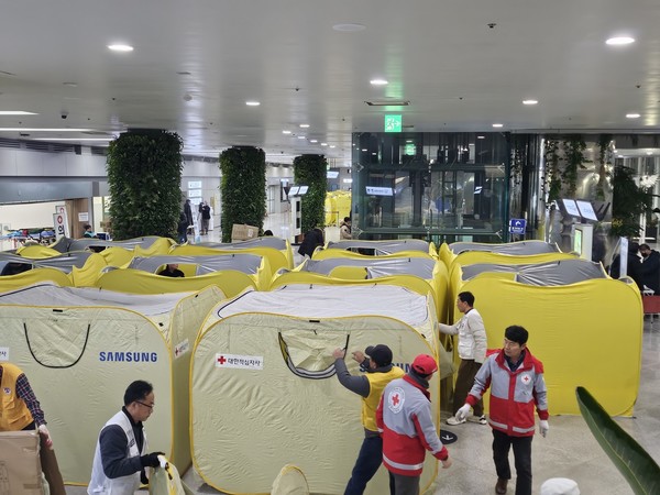 ※사진설명 : 29일 무안공항에서 발생한 여객기 참사 피해자 가족 지원을 위해 대한적십자사 광주전남지사 직원 및 봉사원들이 긴급구호텐트를 설치하고 있다. (출처: 대한적십자사)