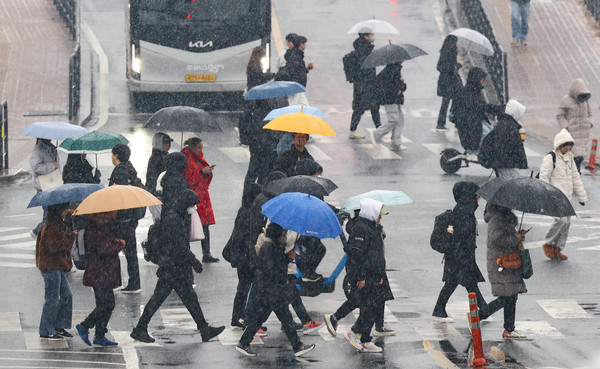 전국 대부분 지역에 눈 또는 비가 내린 12일 서울 서대문구 성산로에서 우산을 쓴 시민들이 발걸음을 재촉하고 있다. 2025.02.12