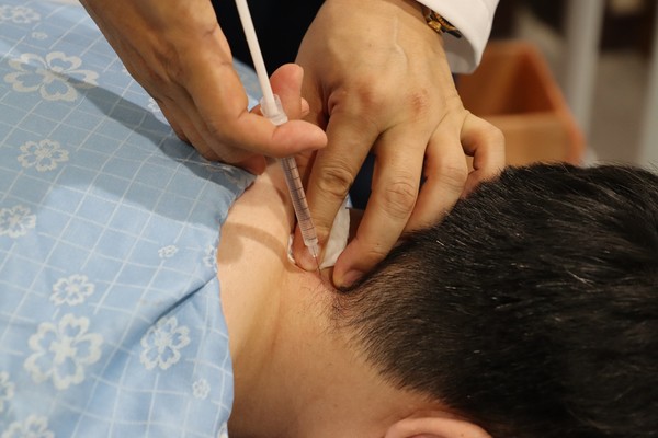 [사진설명]자생한방병원 의료진이 목디스크 환자에게 약침 치료를 실시하고 있다(출처 : 자생한방병원)