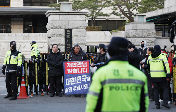 윤석열 대통령 탄핵 심판 선고를 앞둔 14일 서울 종로구 헌법재판소 앞에 윤 대통령 지지자들이 손팻말을 들고 있다. 2025.03.14