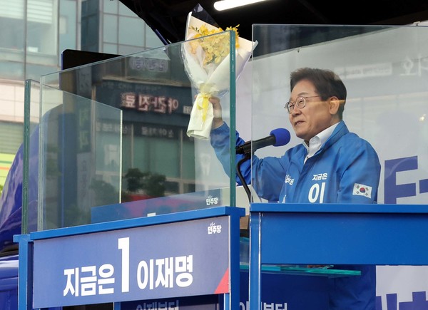이재명 더불어민주당 대선 후보가 24일 경기 안산 단원구 안산문화광장에서 열린 유세에서 세월호 유가족에게 받은 꽃을 들고 지지를 호소하고 있다. 2025.05.24