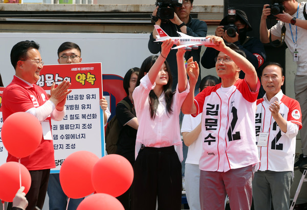 김문수 국민의힘 대선 후보가 30일 충북 충주 젊음의거리에서 유세를 하기 전 청년 참가자에게 '항공물류 허브공항' 메시지가 적힌 모형 비행기를 들어 보이고 있다. 2025.05.30.