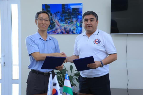 박남식 (사)한국이주민고용지원중앙회 우즈베키스탄 지사장(왼쪽)과 이민오브 알리세르 우즈베키스탄 페르가나 코니카 직업훈련센터장과 협약서를 교환하고 있다.