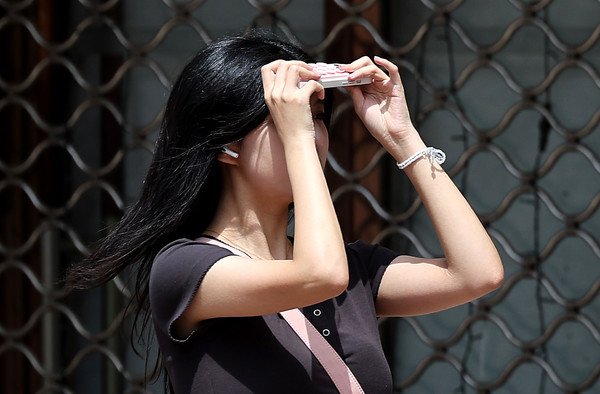 대구 낮 최고기온이 28도까지 오르며 초여름 날씨를 보인 19일 대구 중구 동성로에서 한 시민이 휴대폰으로 햇빛을 가린 채 길을 걷고 있다. 2025.05.19.