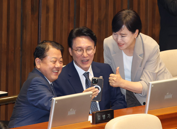 김민석(가운데) 국무총리 후보자가 3일 서울 여의도 국회에서 열린 제426회 국회(임시회) 제4차 본회의에서 김병주 더불어민주당 의원의 SNS 방송을 하고 있다. 왼쪽부터 김병주, 김민석, 전현희 의원. 2025.06.24.